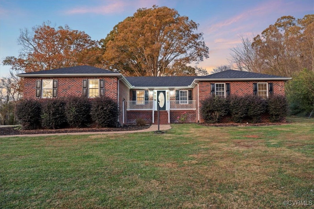 Ranch-style home featuring a lawn