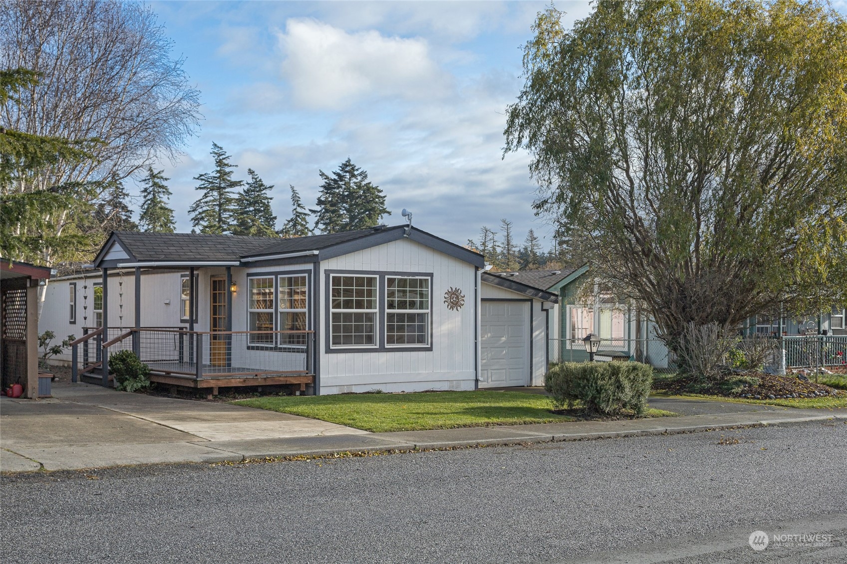 a front view of a house with a garden and trees