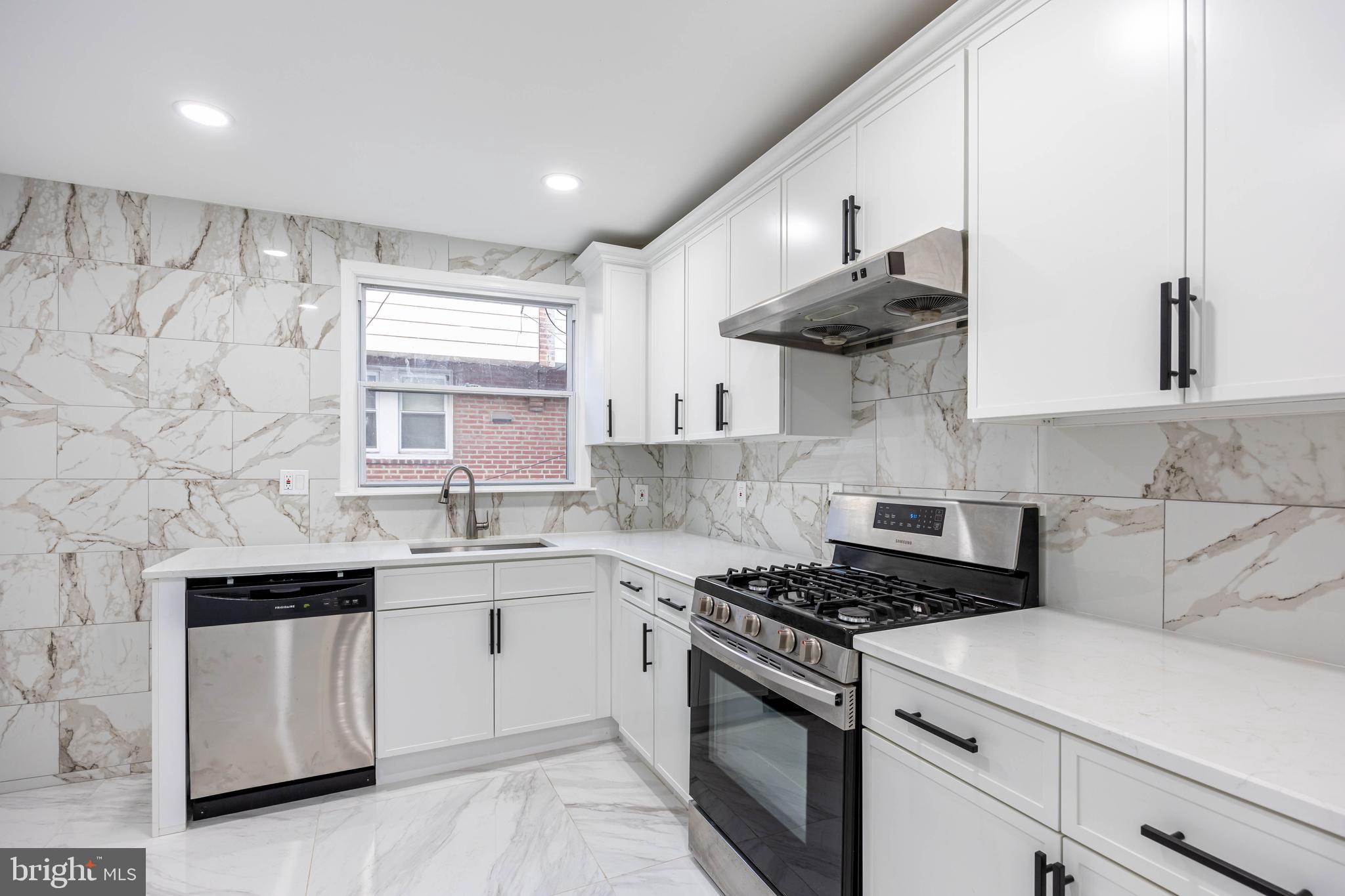 a kitchen with stainless steel appliances a sink stove and cabinets