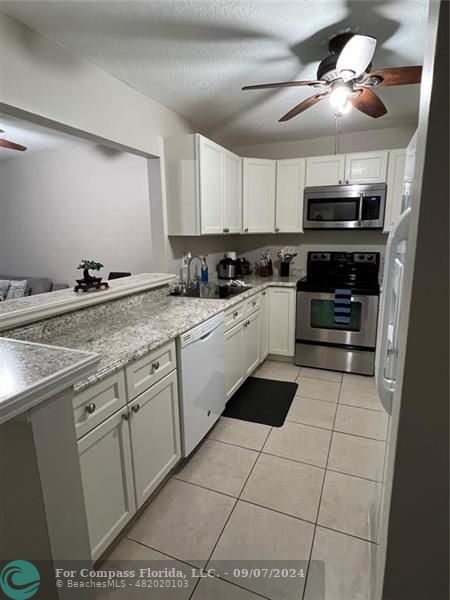 a kitchen with a stove a sink and a microwave