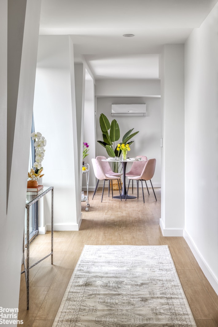 a dining room with furniture a rug and a potted plant