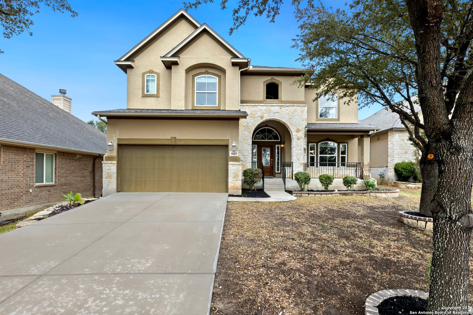 a front view of a house with yard and parking