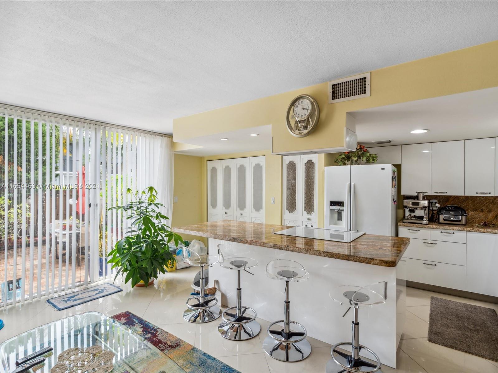 a kitchen with stainless steel appliances kitchen island granite countertop a table and chairs in it