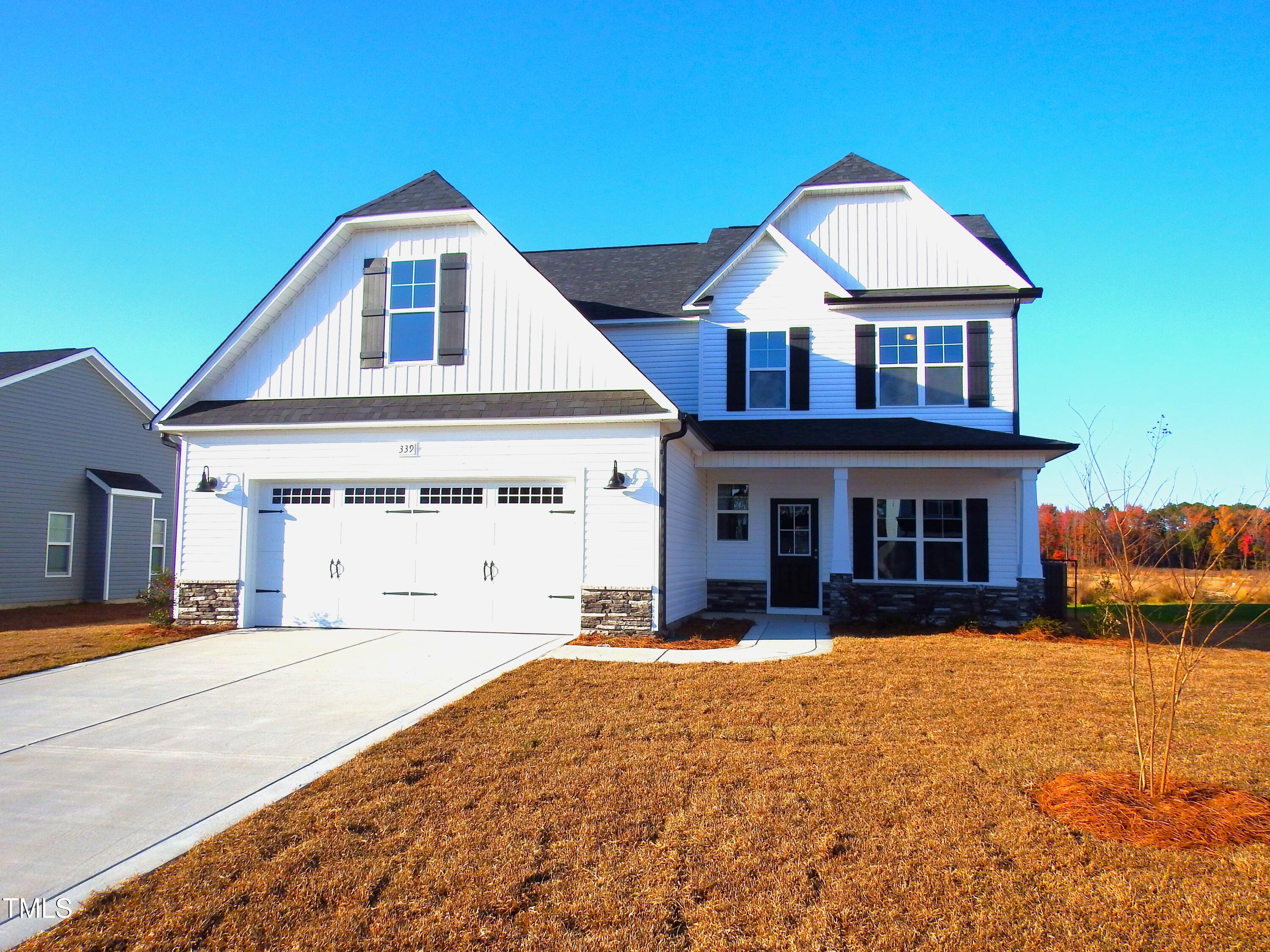 a front view of a house with yard and parking