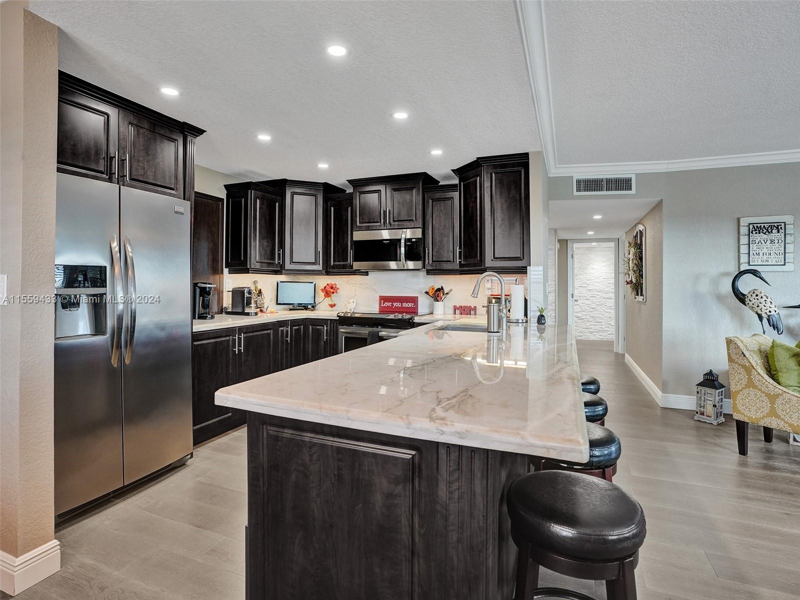 a kitchen with stainless steel appliances a refrigerator sink and microwave