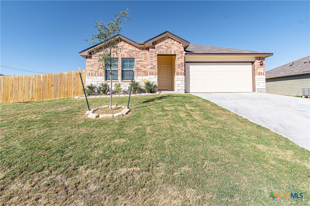 a view of a house with a yard and a garage