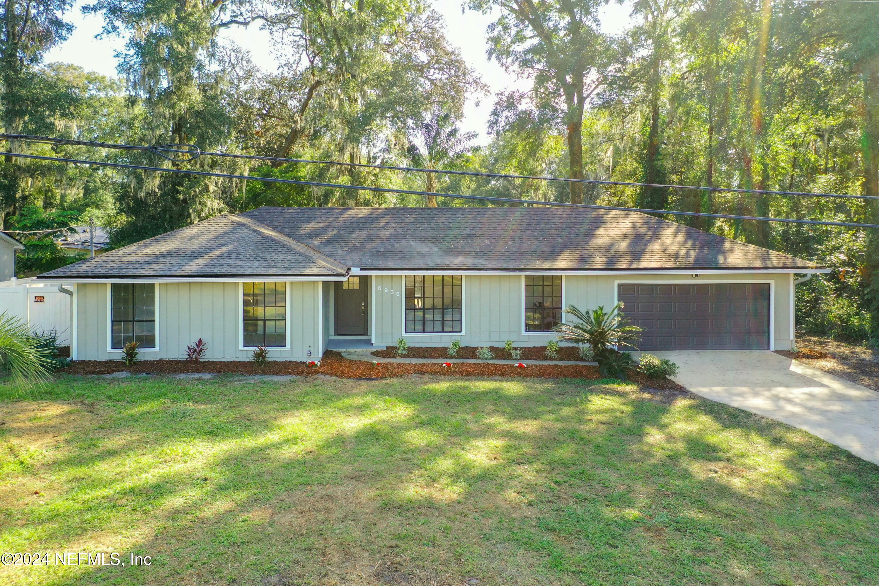 a view of a house with a yard and sitting area