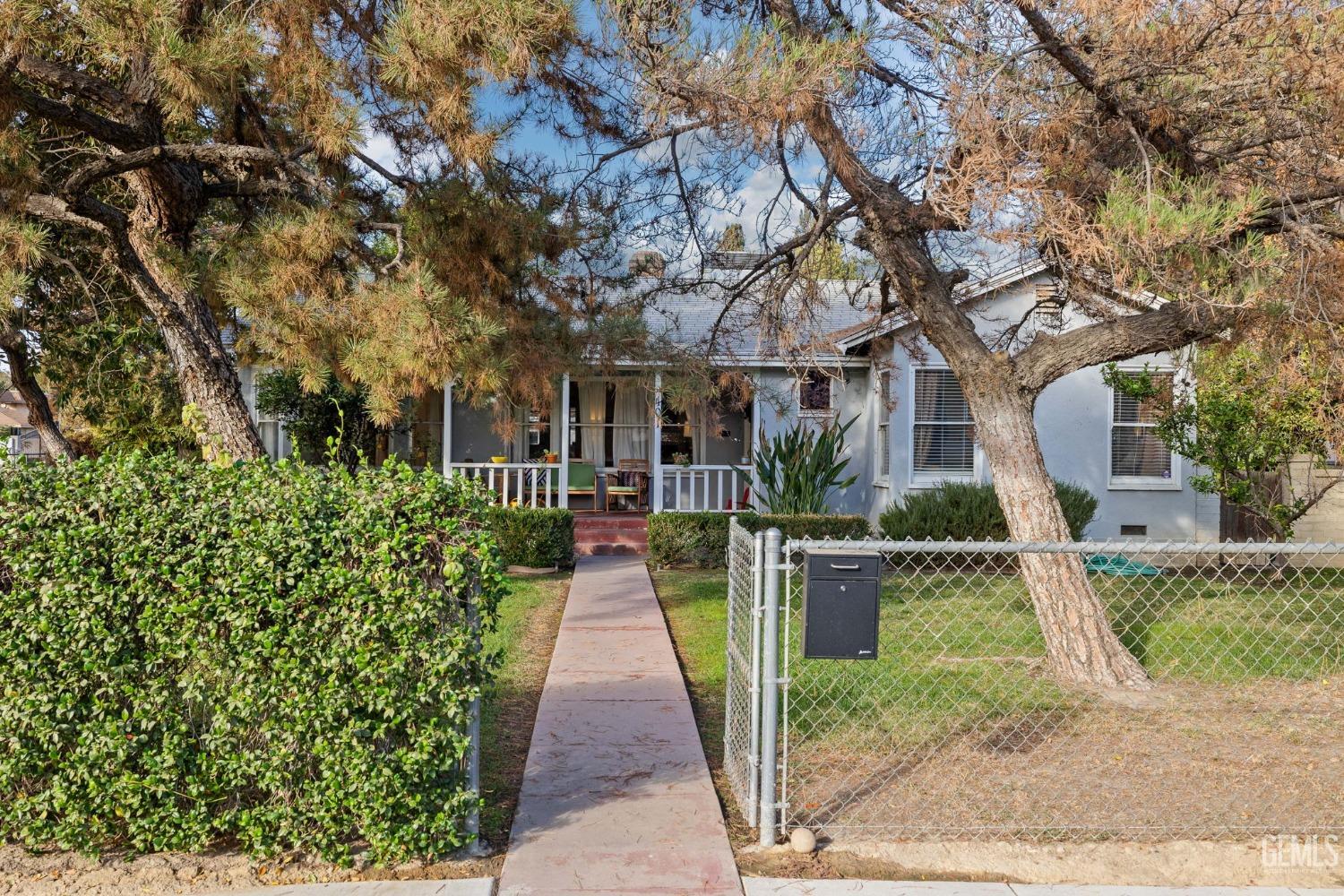 a front view of a house with a yard and potted plants