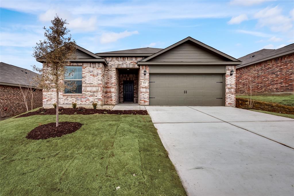 a front view of a house with garage and plants