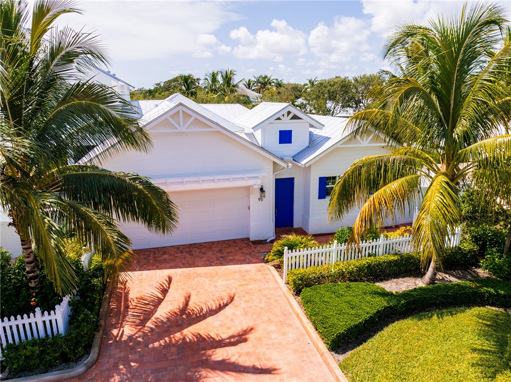 a view of a house with a yard and potted plants