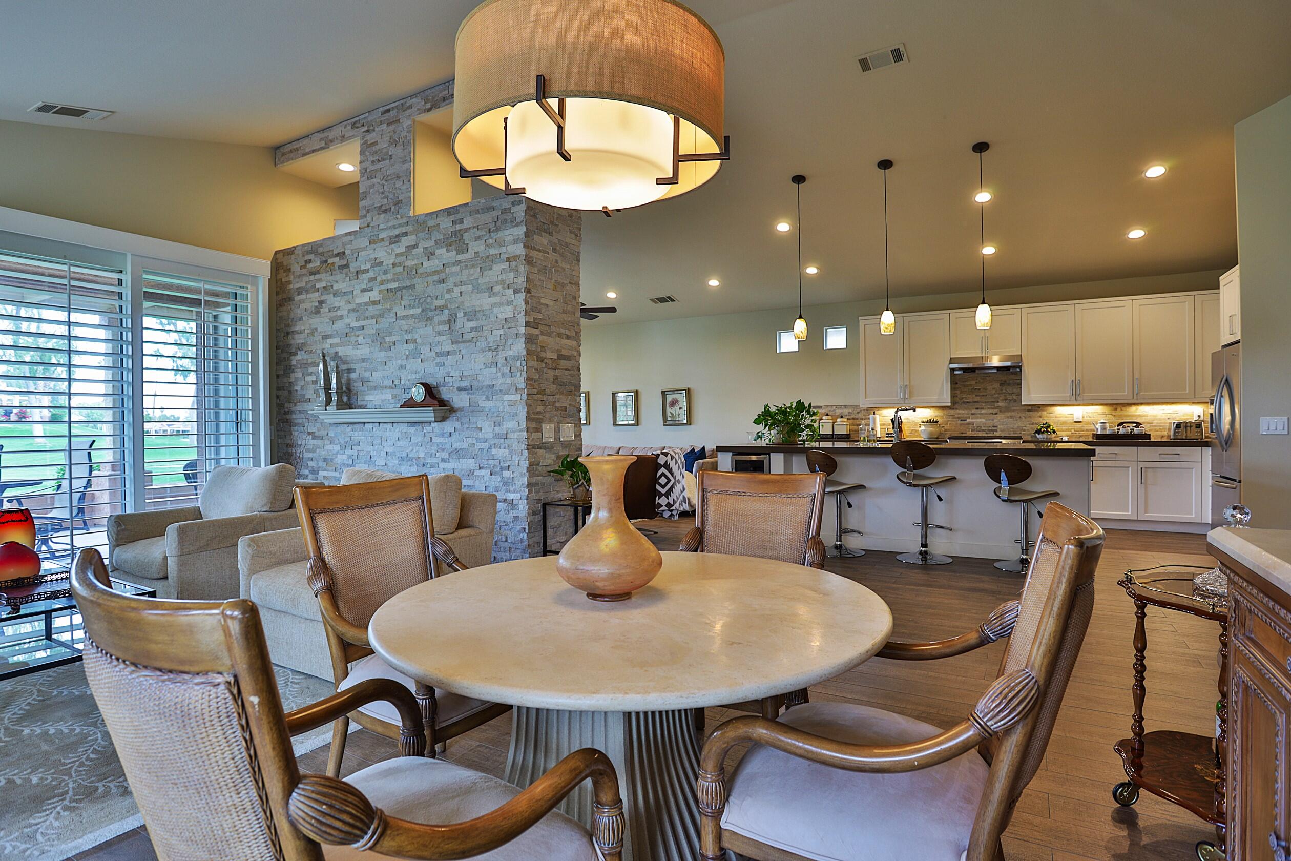 a kitchen with stainless steel appliances kitchen island granite countertop a table and chairs