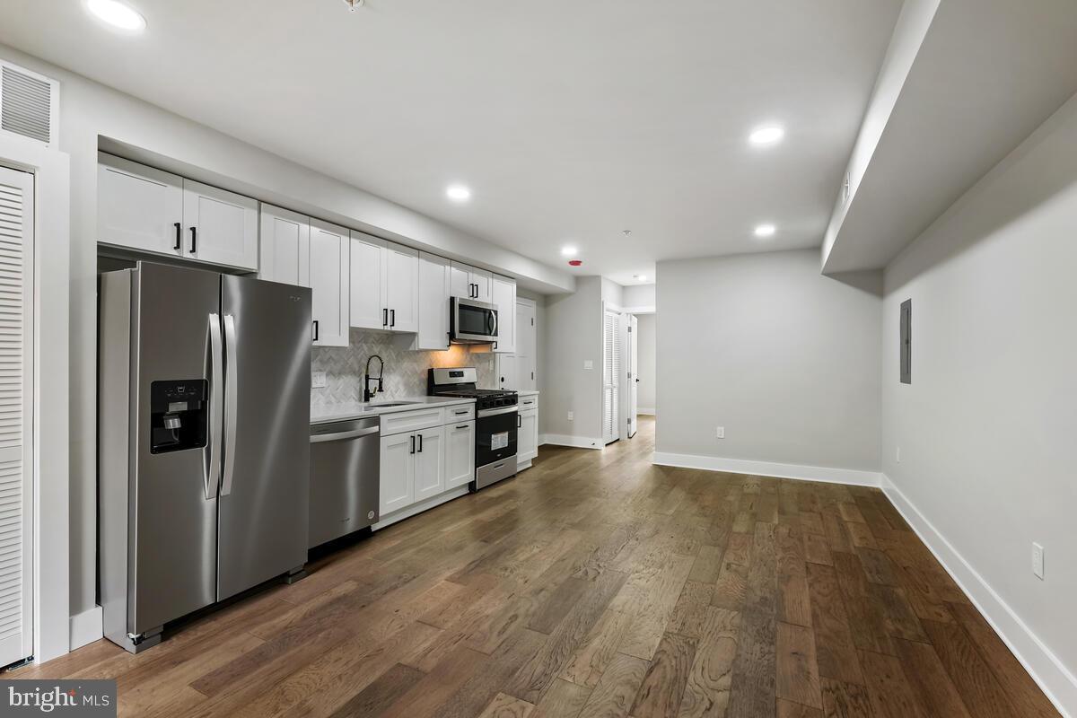 a kitchen with stainless steel appliances a refrigerator and a stove top oven