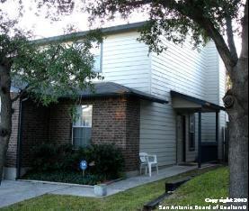 a view of a house with brick walls and a tree