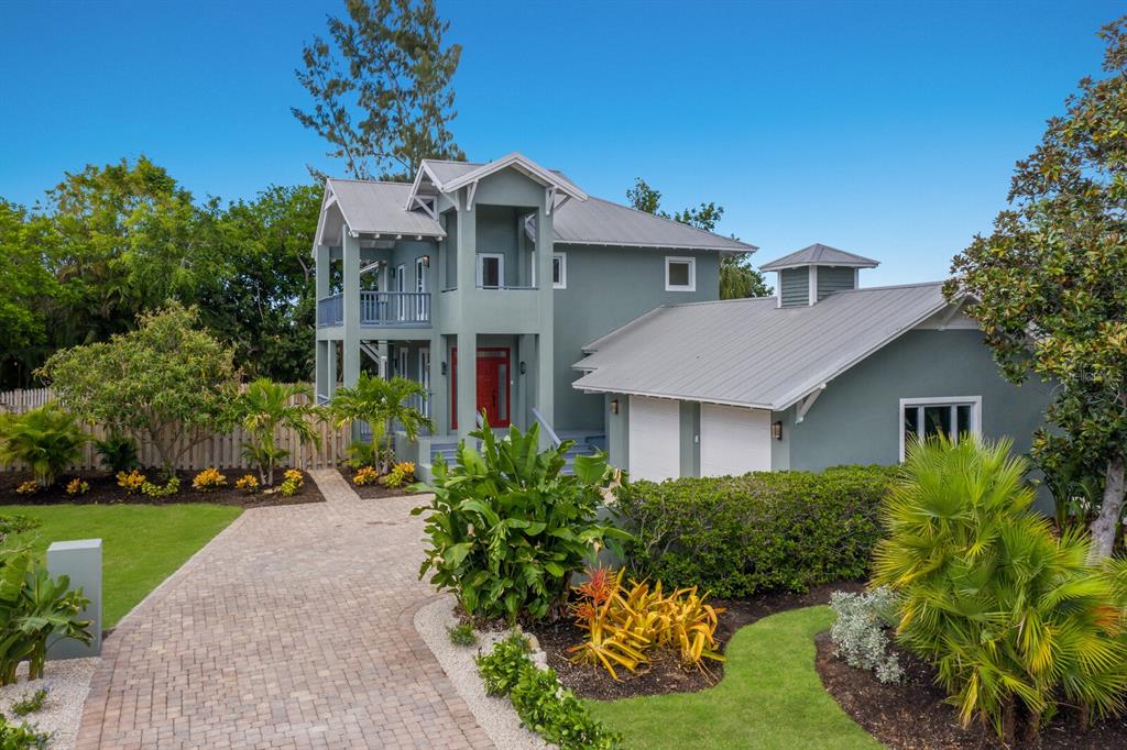 a front view of a house with a yard and potted plants