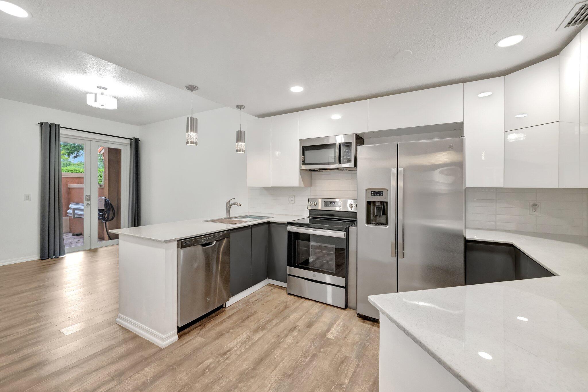 a large kitchen with stainless steel appliances and a refrigerator