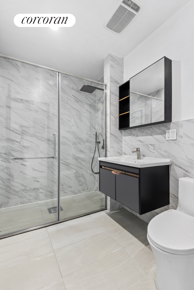 a bathroom with a double vanity sink toilet and mirror