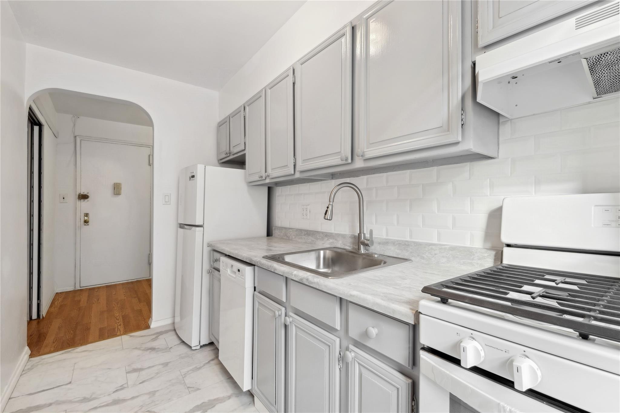 a kitchen with granite countertop a sink stove and cabinets