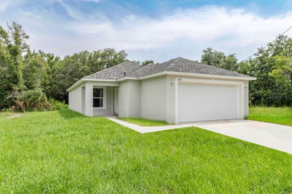 a front view of a house with a yard and garage