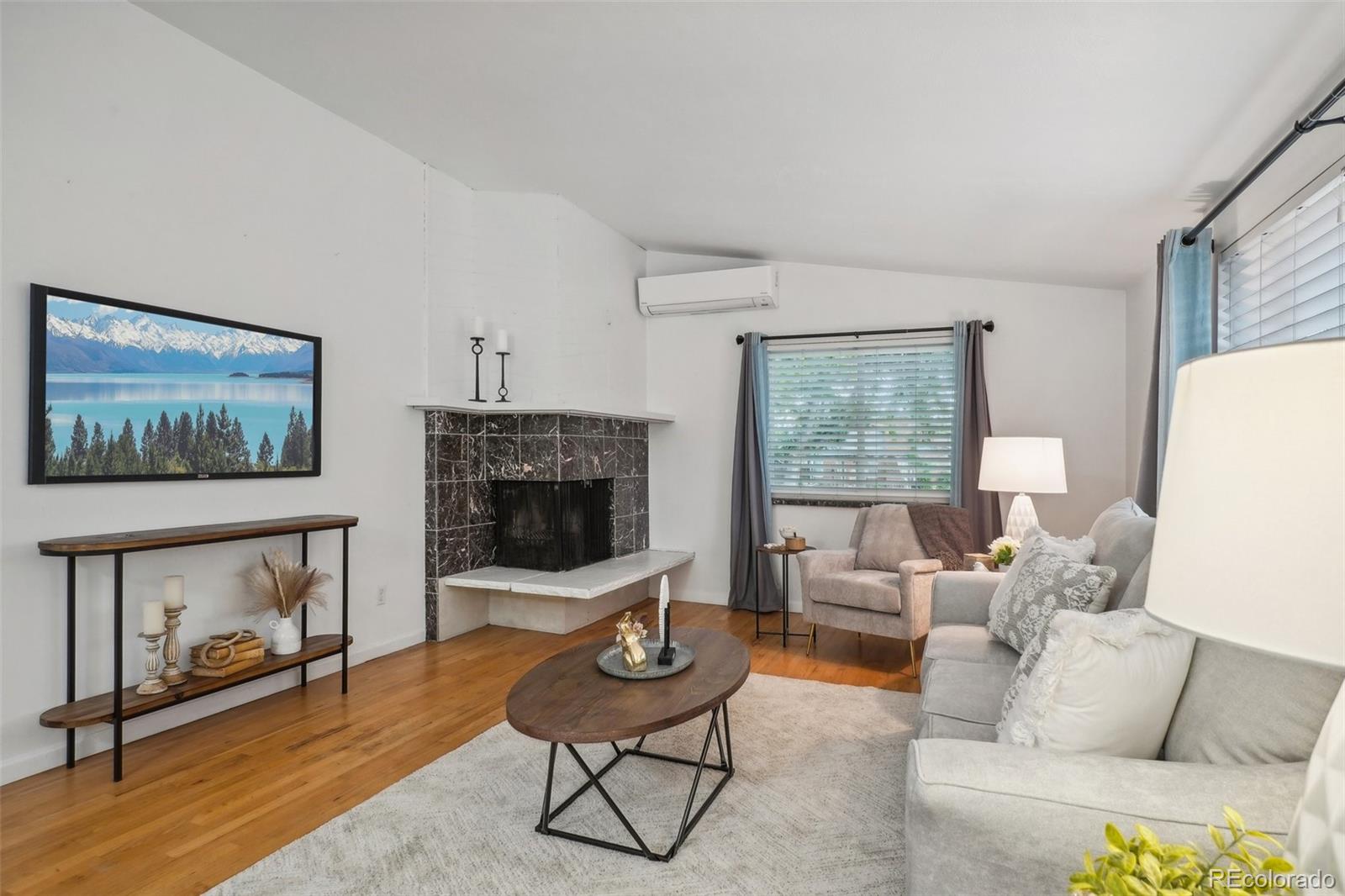 a living room with furniture a flat screen tv and a fireplace