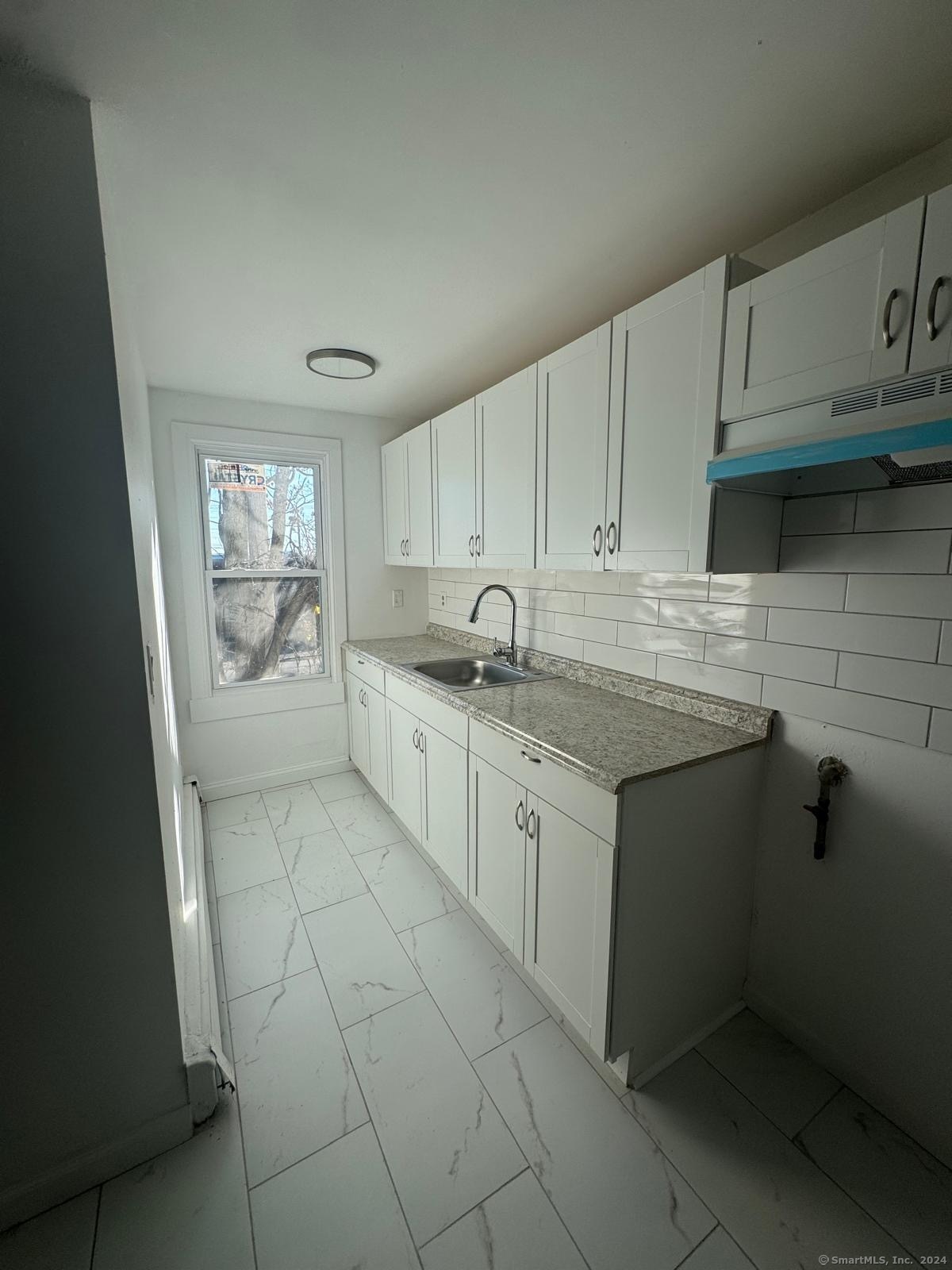 a kitchen with a sink window and cabinets