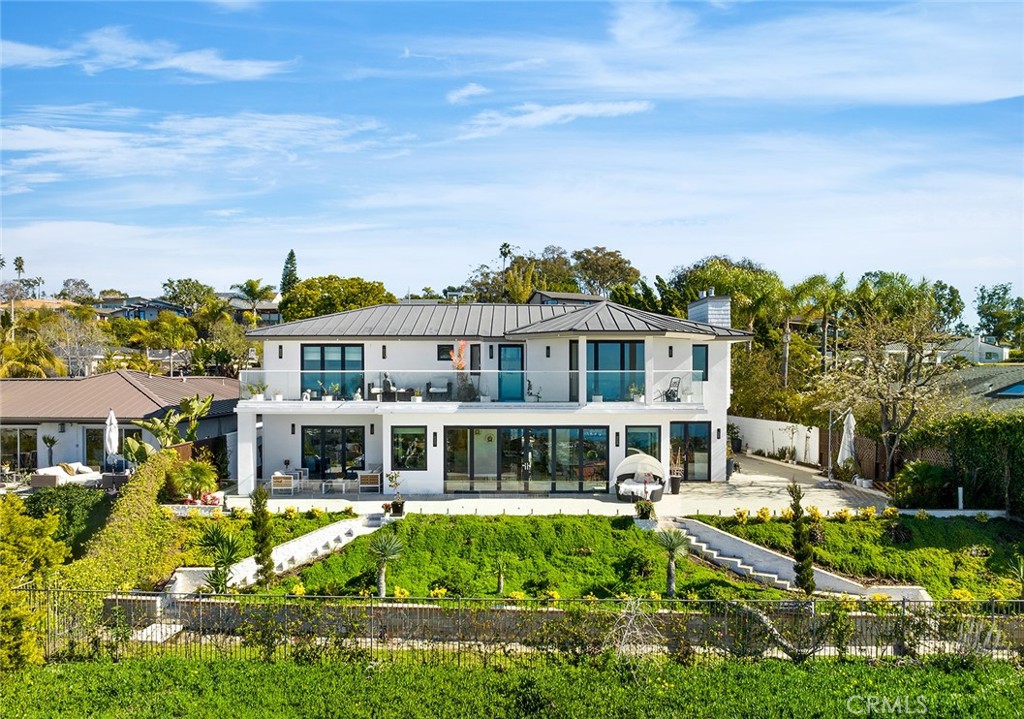 a view of a house with a big yard plants and large trees