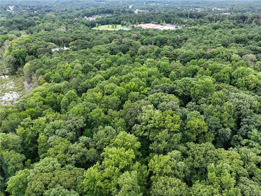 an aerial view of residential house with outdoor space and trees all around