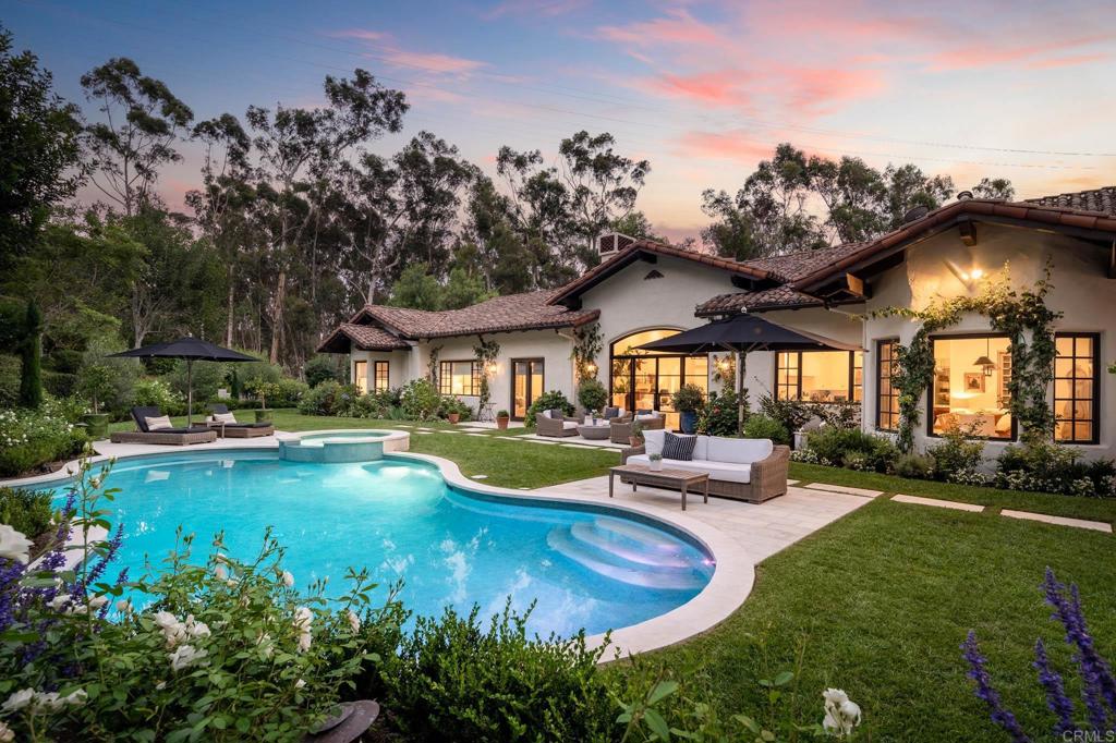 a view of a house with swimming pool and sitting area