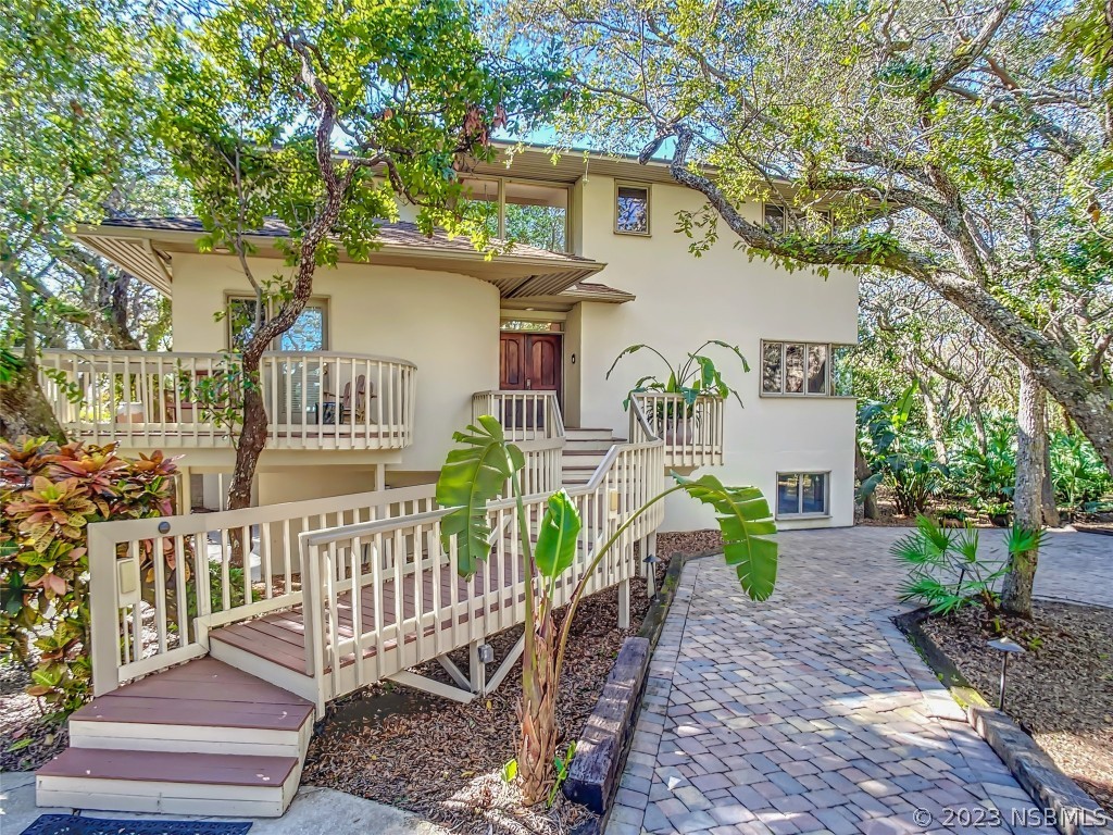 a view of a house with a patio and a garden