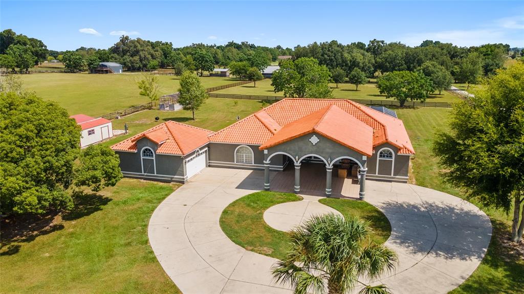 an aerial view of a house with swimming pool and lake view