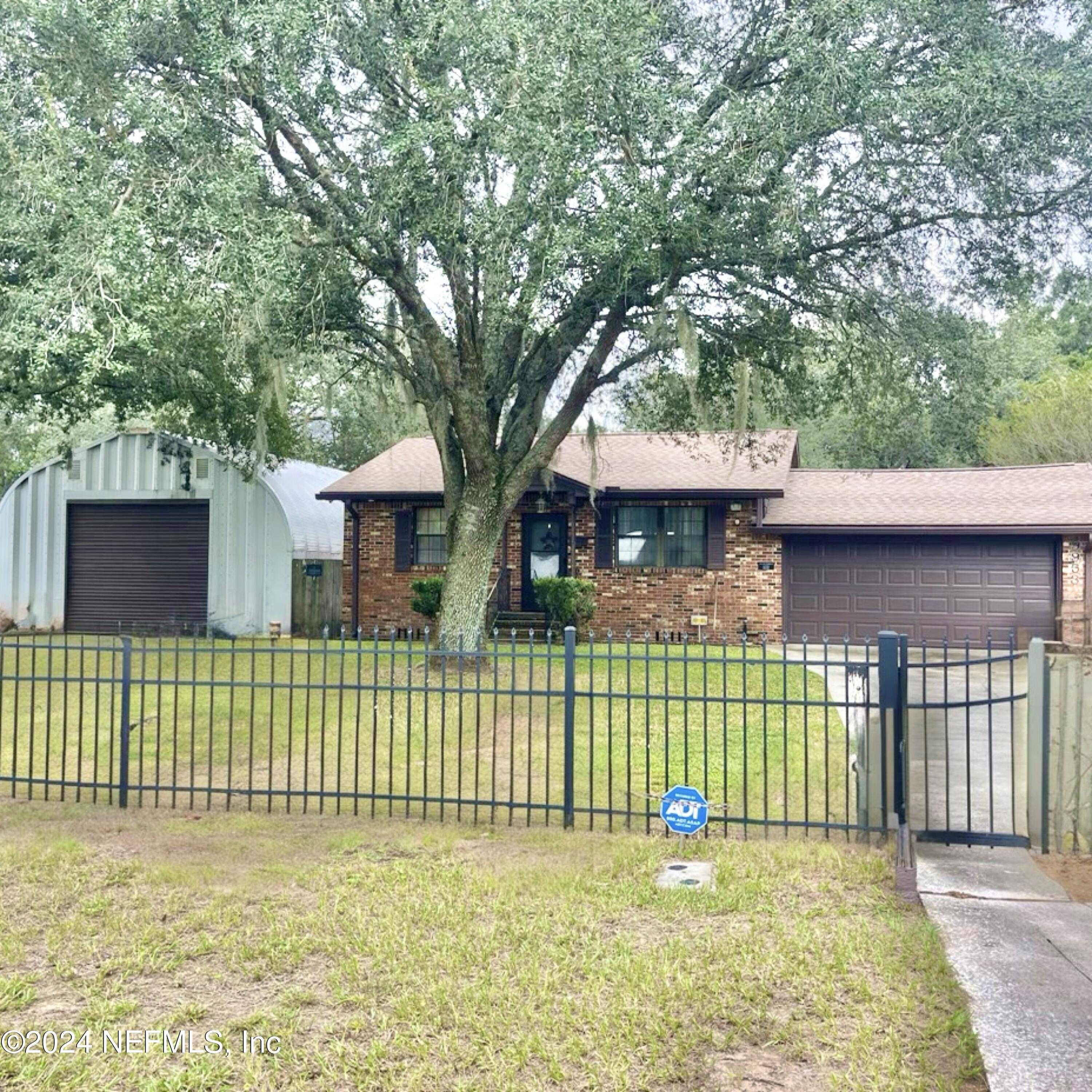 a view of a house with a fence and a big yard