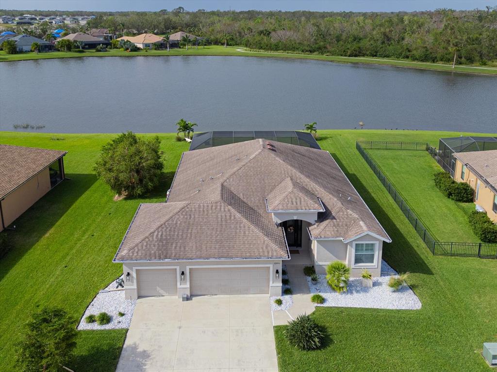 an aerial view of a house with a yard and lake view