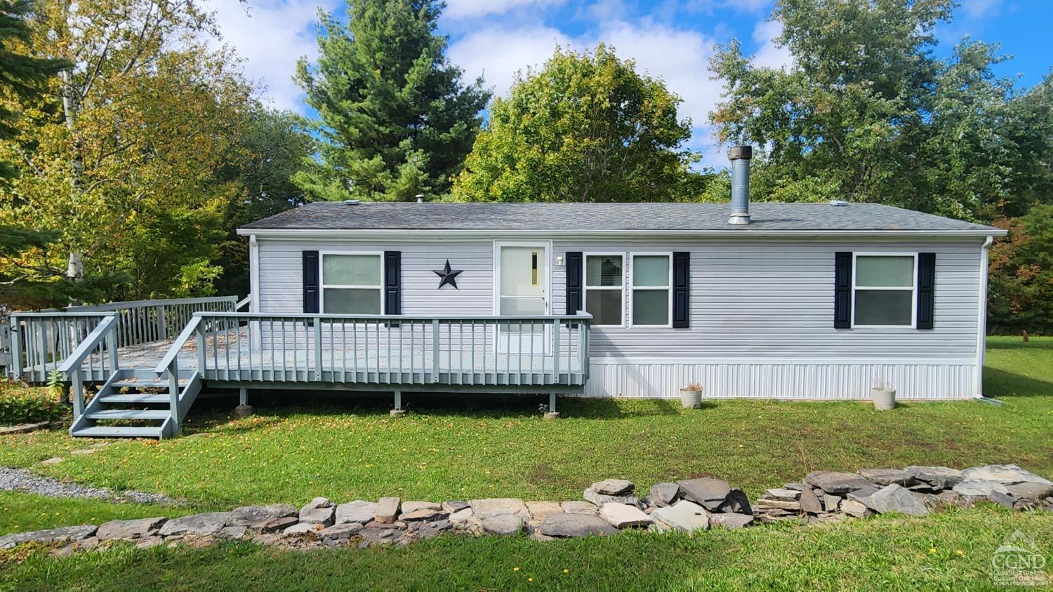 a view of a house with a backyard and deck