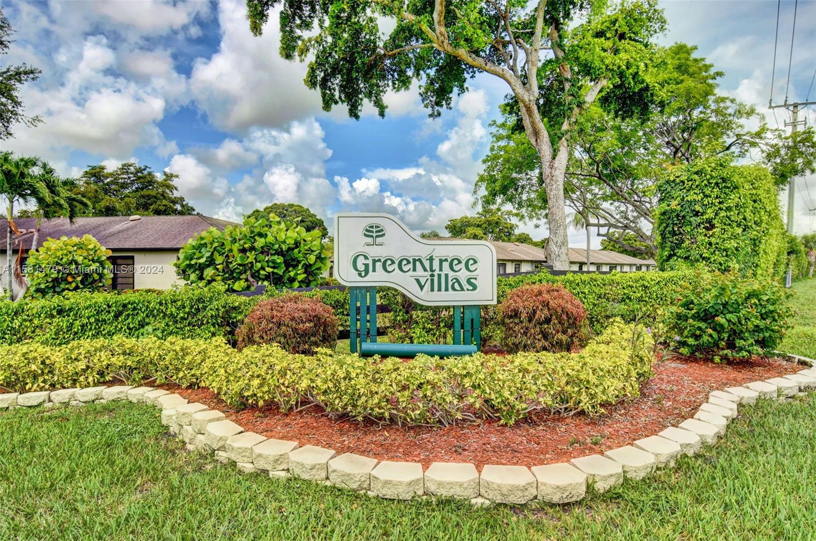 a view of a sign under a tree