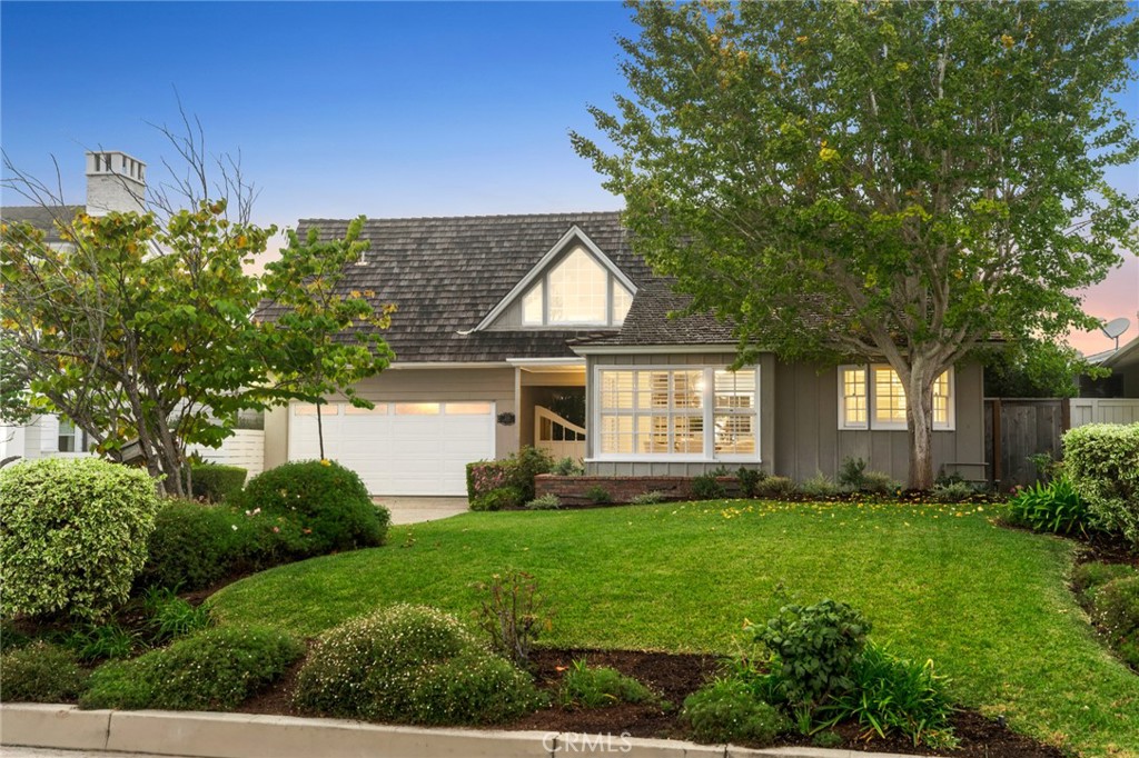 a front view of a house with a yard and trees