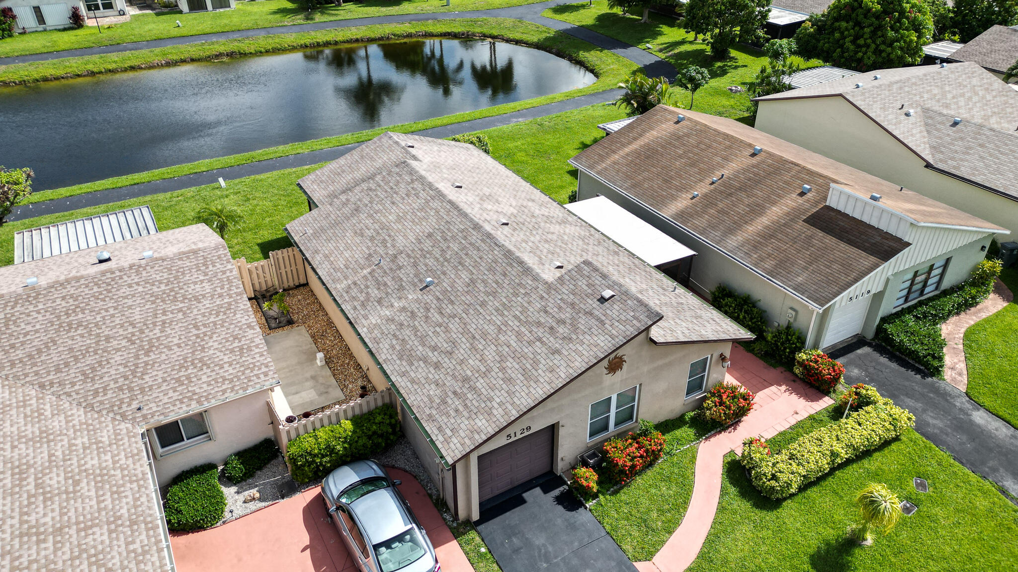 an aerial view of a house with a garden and lake view