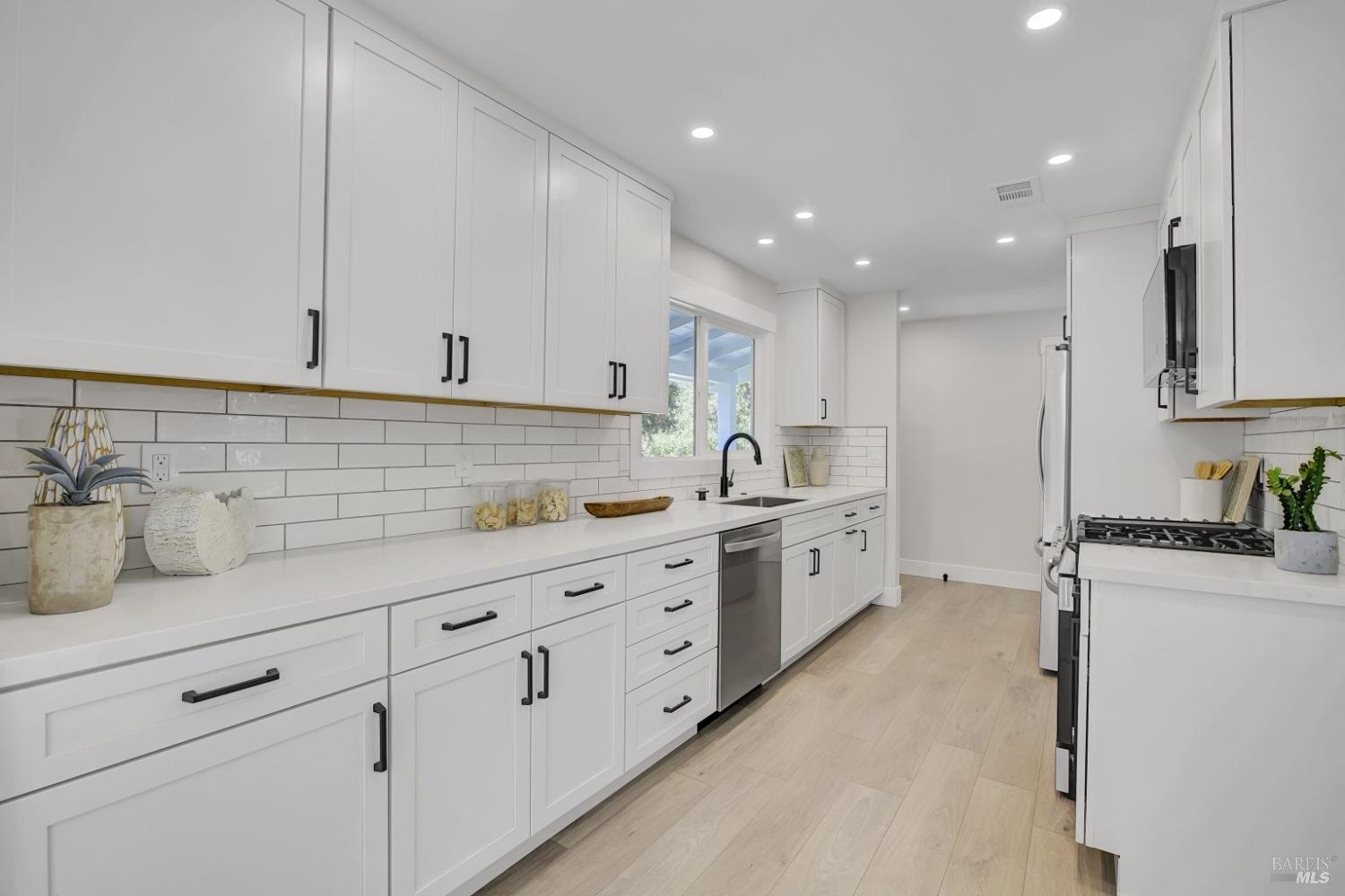 a kitchen with granite countertop white cabinets and white appliances