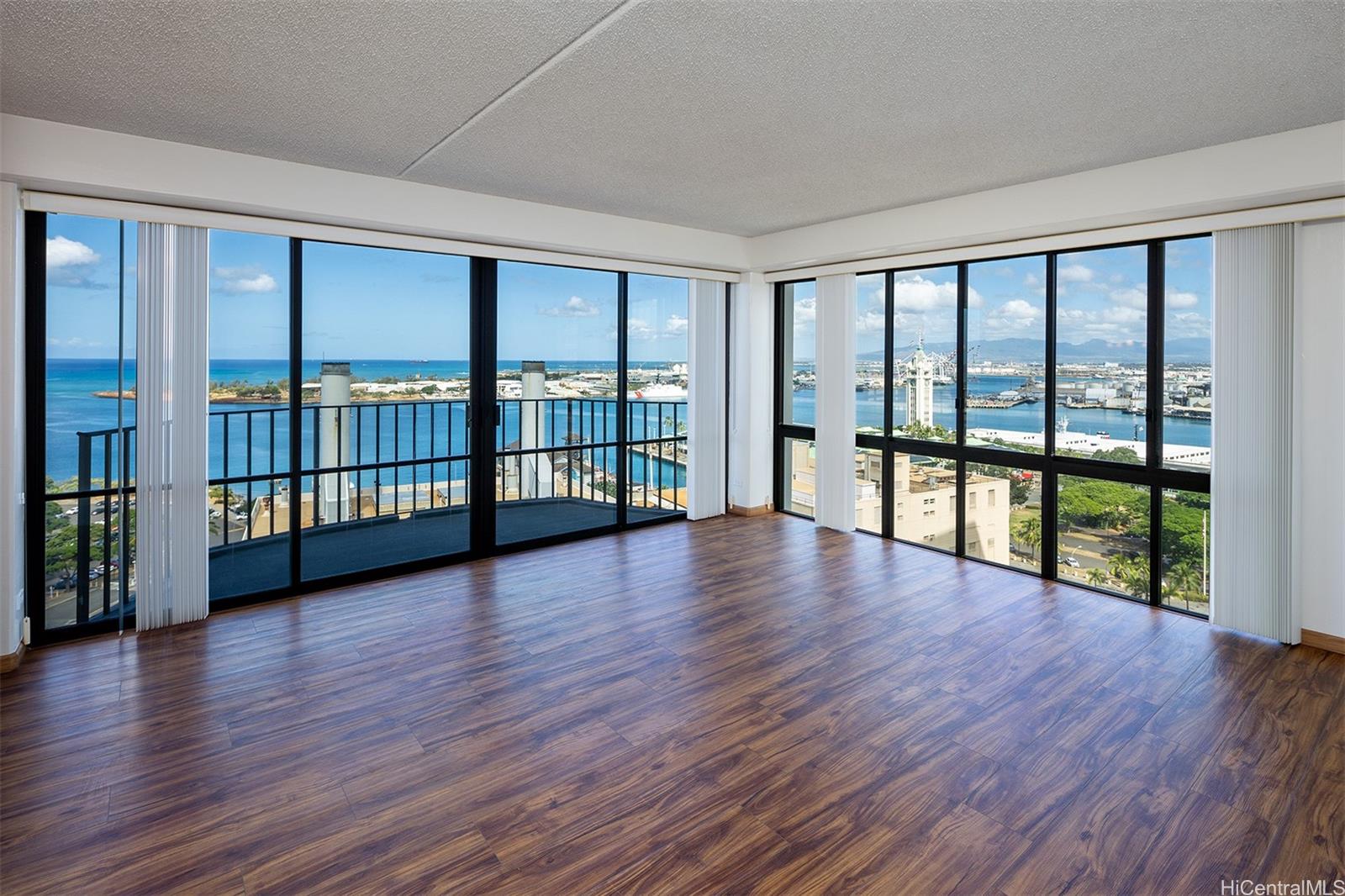 a view of empty room with wooden floor and floor to ceiling window