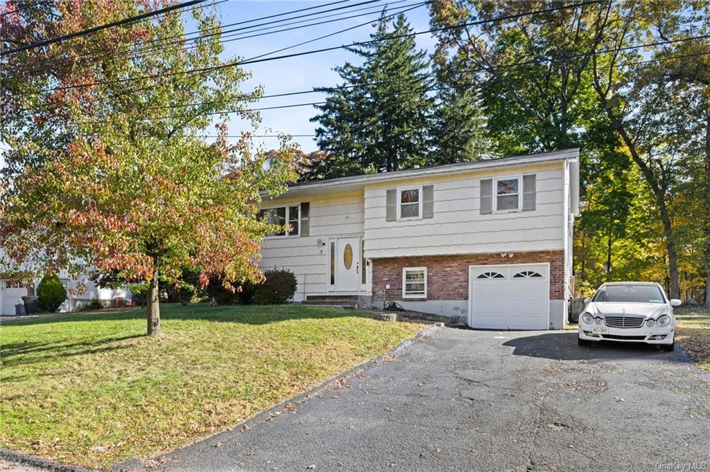 Bi-level home featuring a front lawn and a garage