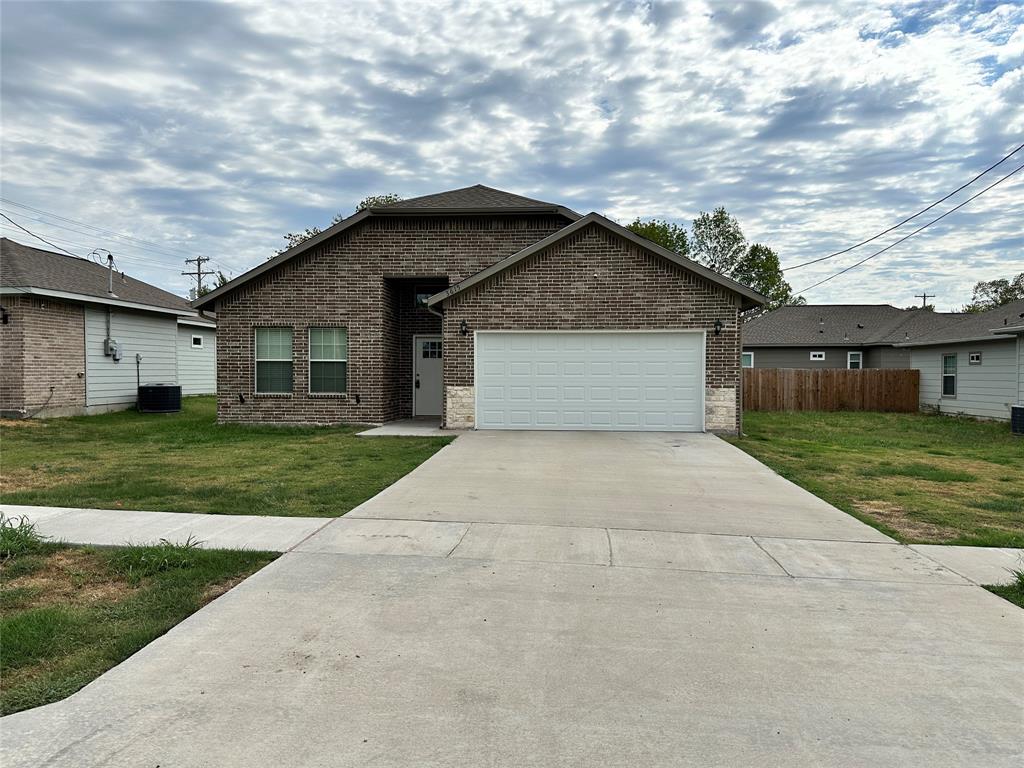 a front view of house with yard and garage