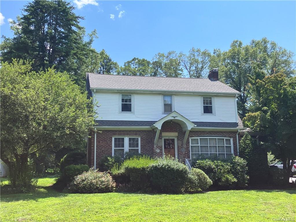 a front view of a house with yard and green space