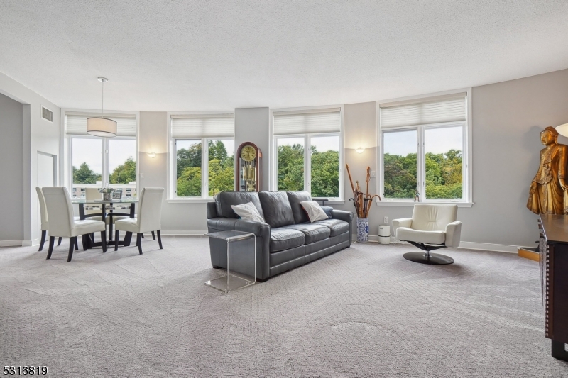 a living room with furniture and floor to ceiling windows