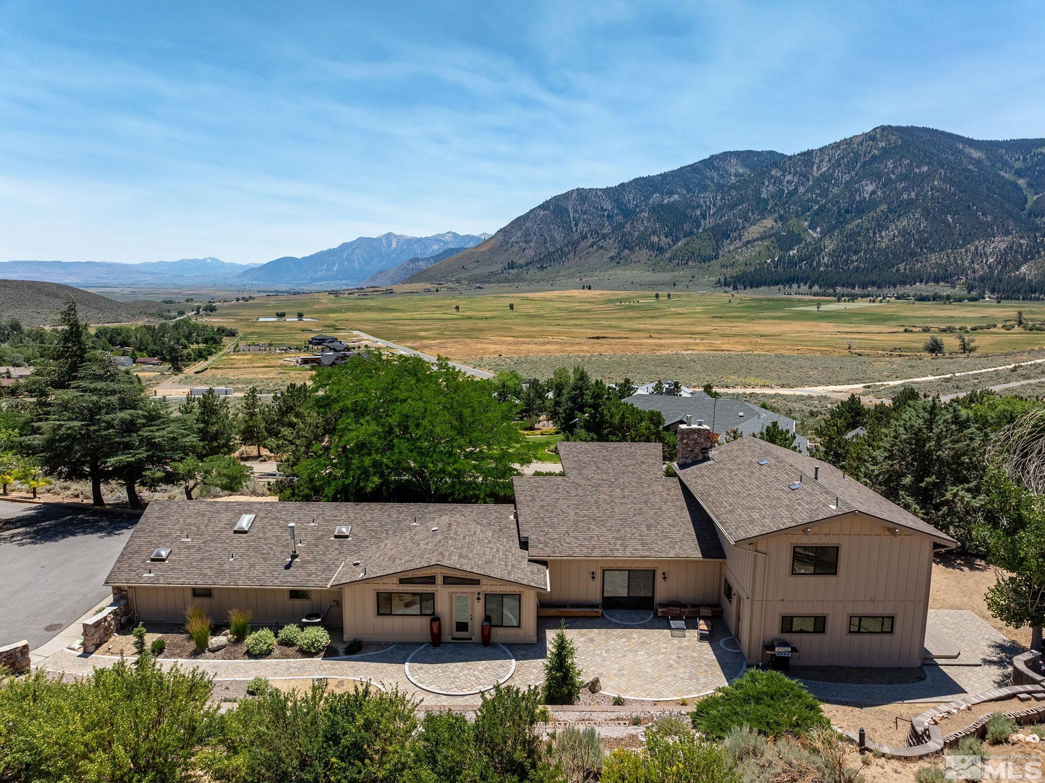 an aerial view of a house with a garden and lake view