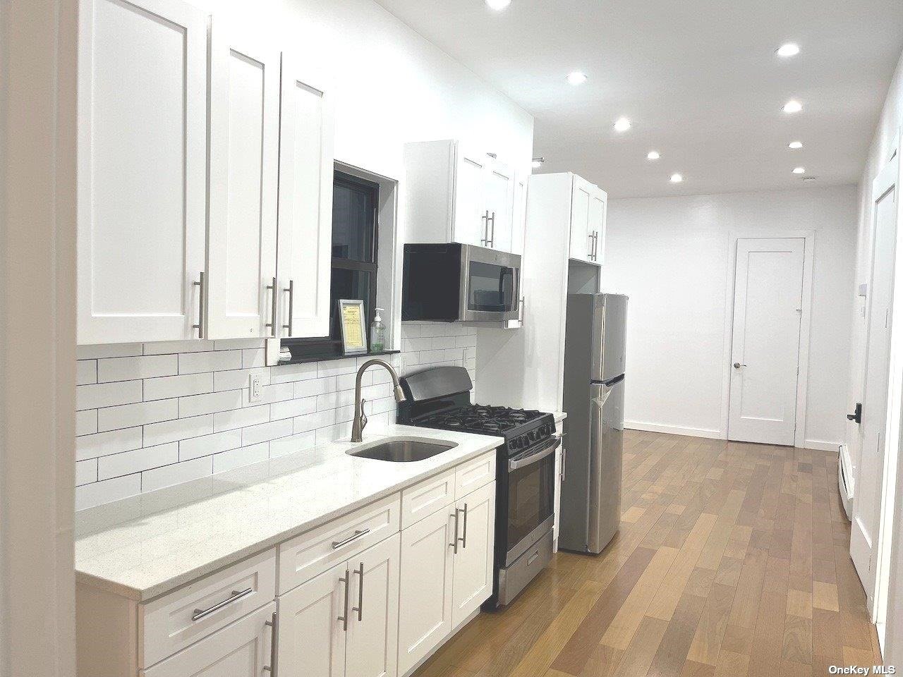 a kitchen with kitchen island granite countertop a sink appliances and cabinets