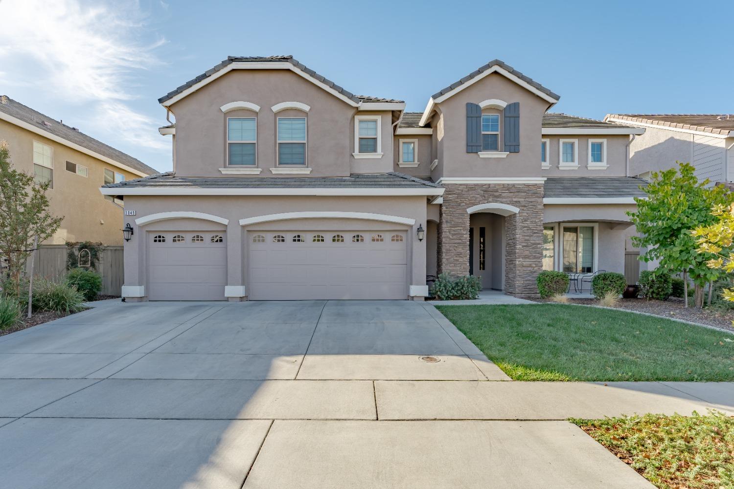 a front view of a house with yard and parking