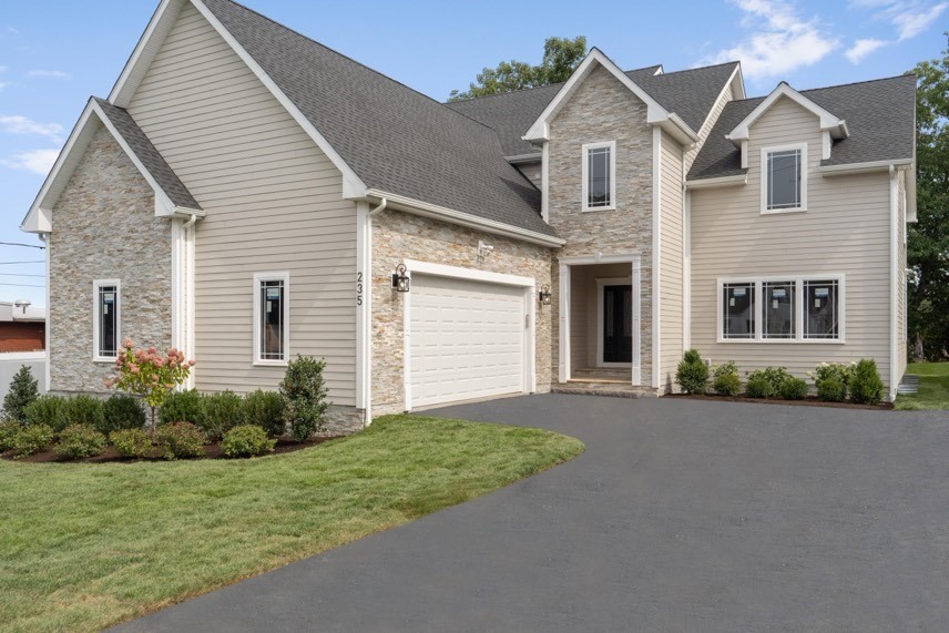 a front view of a house with a garden and yard