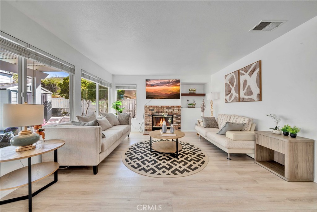 a living room with furniture a fireplace and a large window