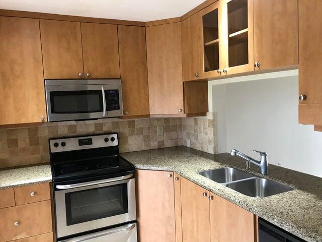 a kitchen with granite countertop a sink and a microwave