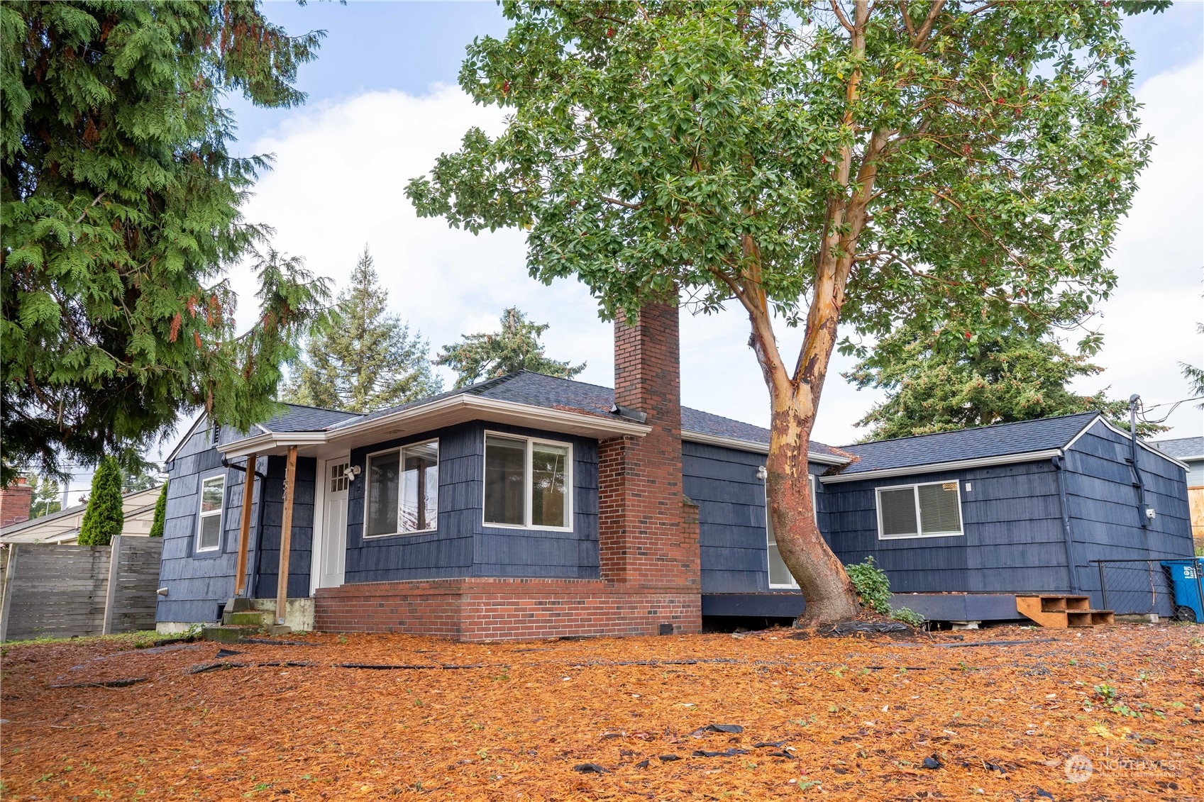 a view of a yard in front of a house with large tree