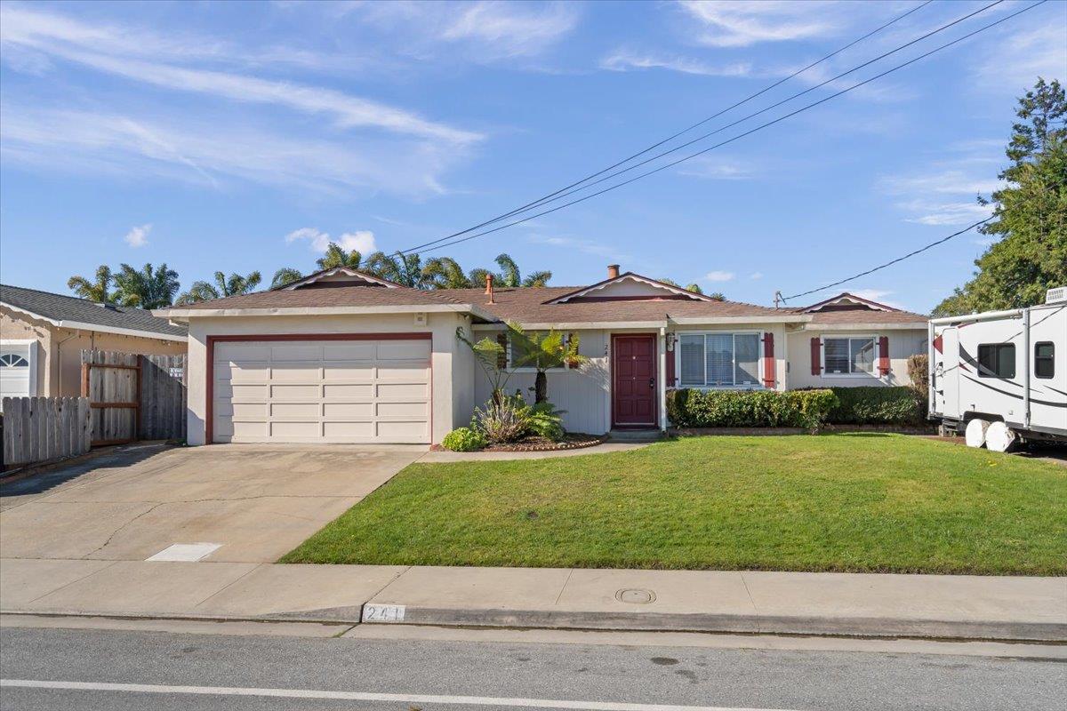 a front view of a house with a yard and potted plants