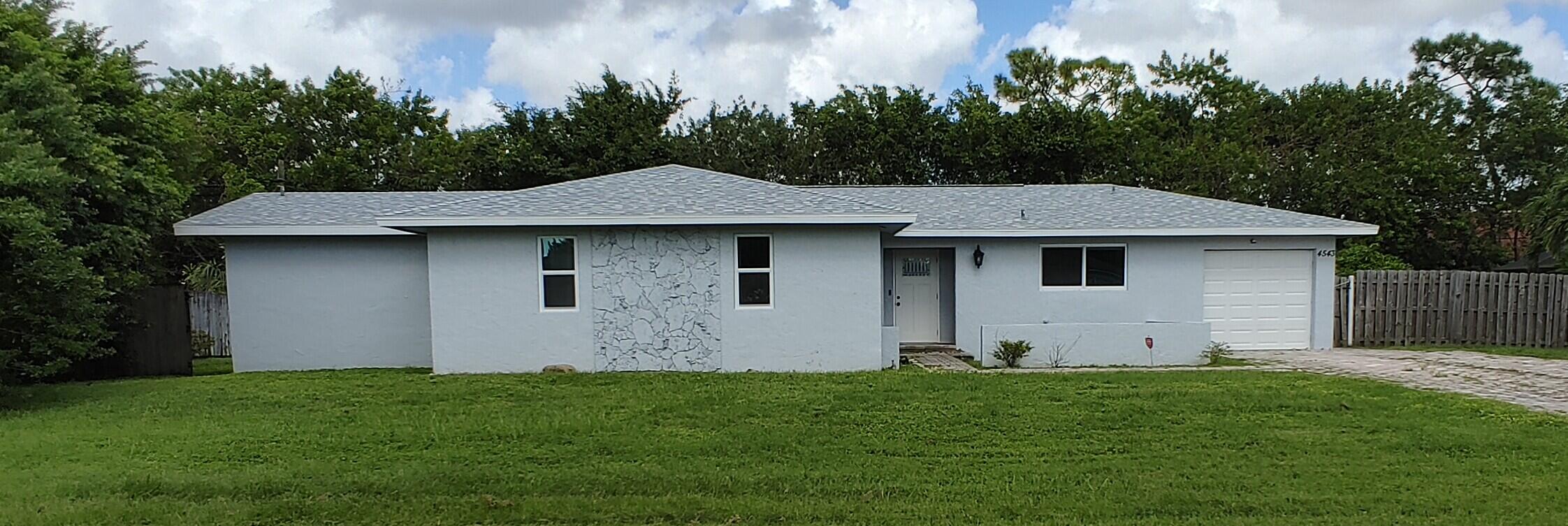 a aerial view of a house with yard and green space